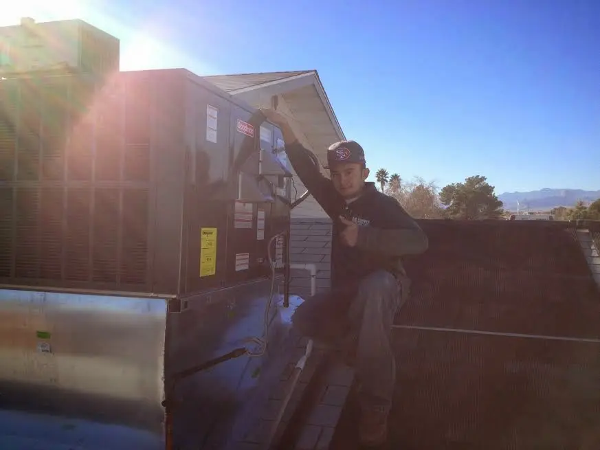 HVAC technician performing Heat Pump Repair on a rooftop unit in Lochmoor Waterway Estates