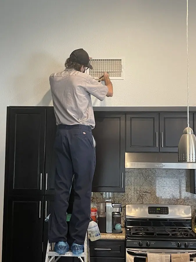 Technician inspecting an air vent during HVAC service in Lochmoor Waterway Estates